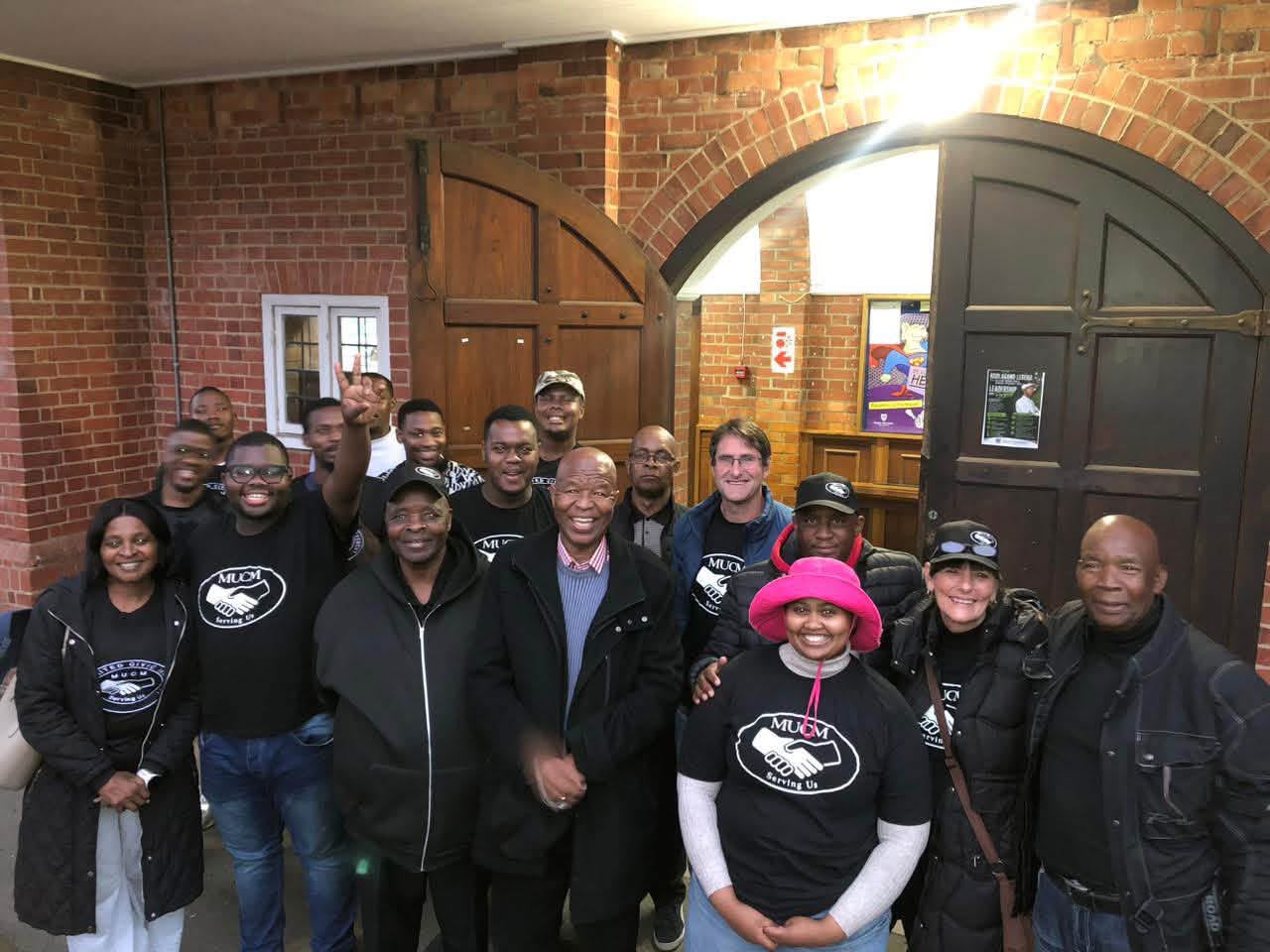 MUCM members gathered at the arched doors