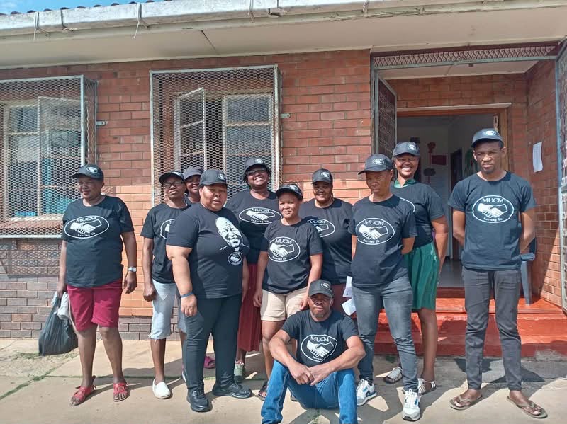MUCM team outside a community building