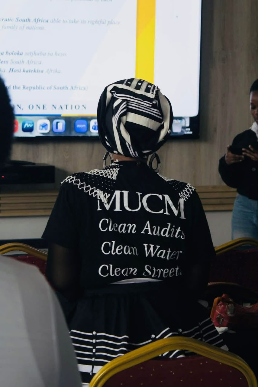 A resident wearing an MUCM shirt reading Clean Audits, Clean Water, Clean Streets